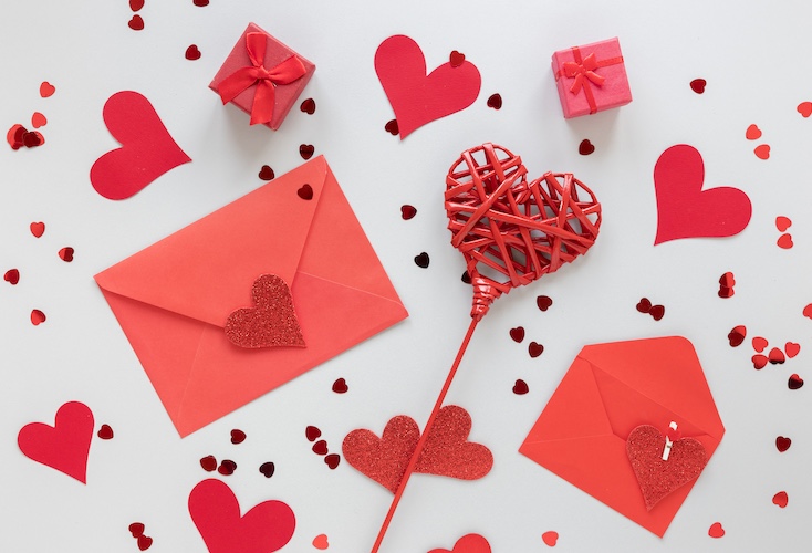 Red valentines envelopes with heart cutouts and glitters and little red presents