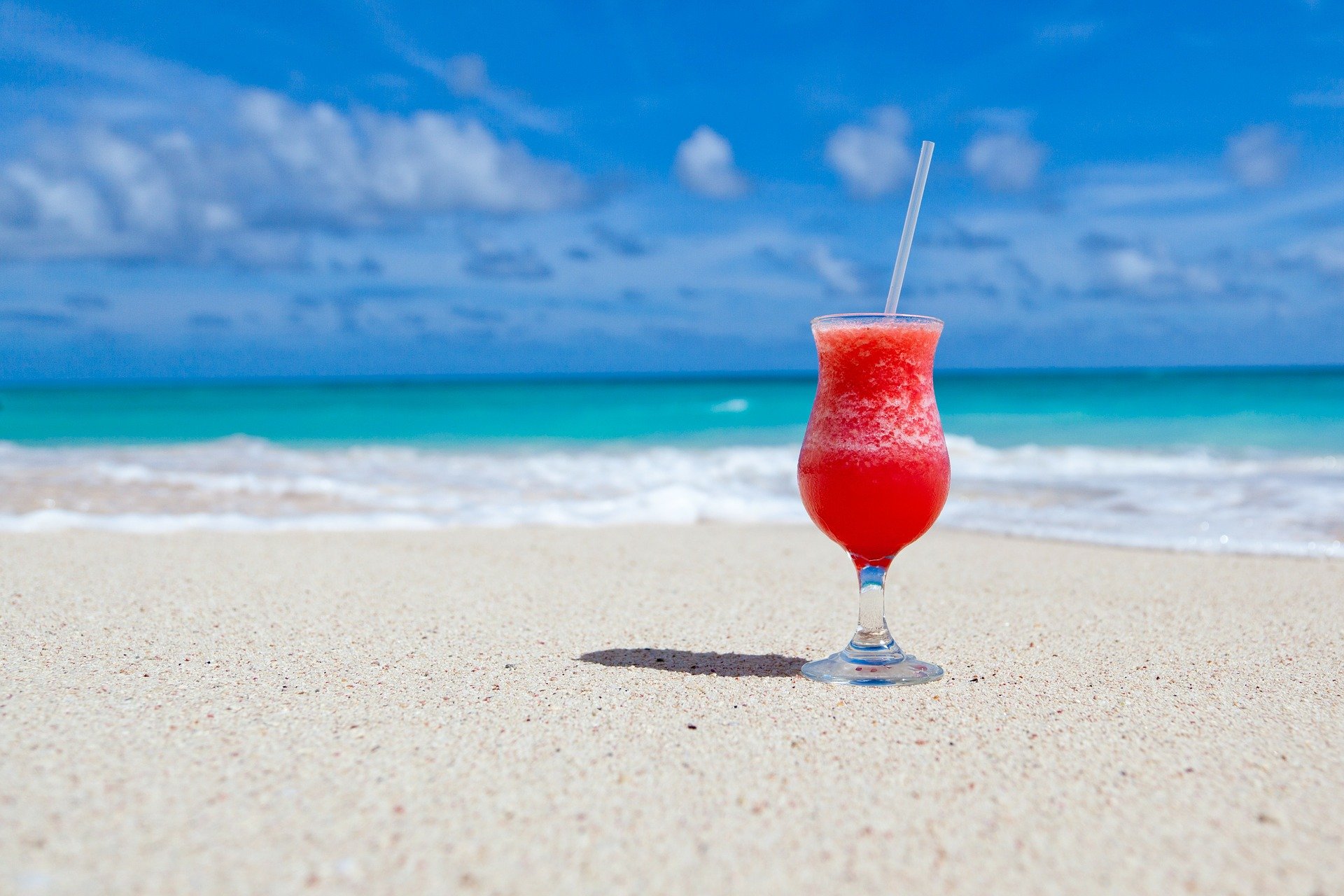 Tropical drink on white sand beach