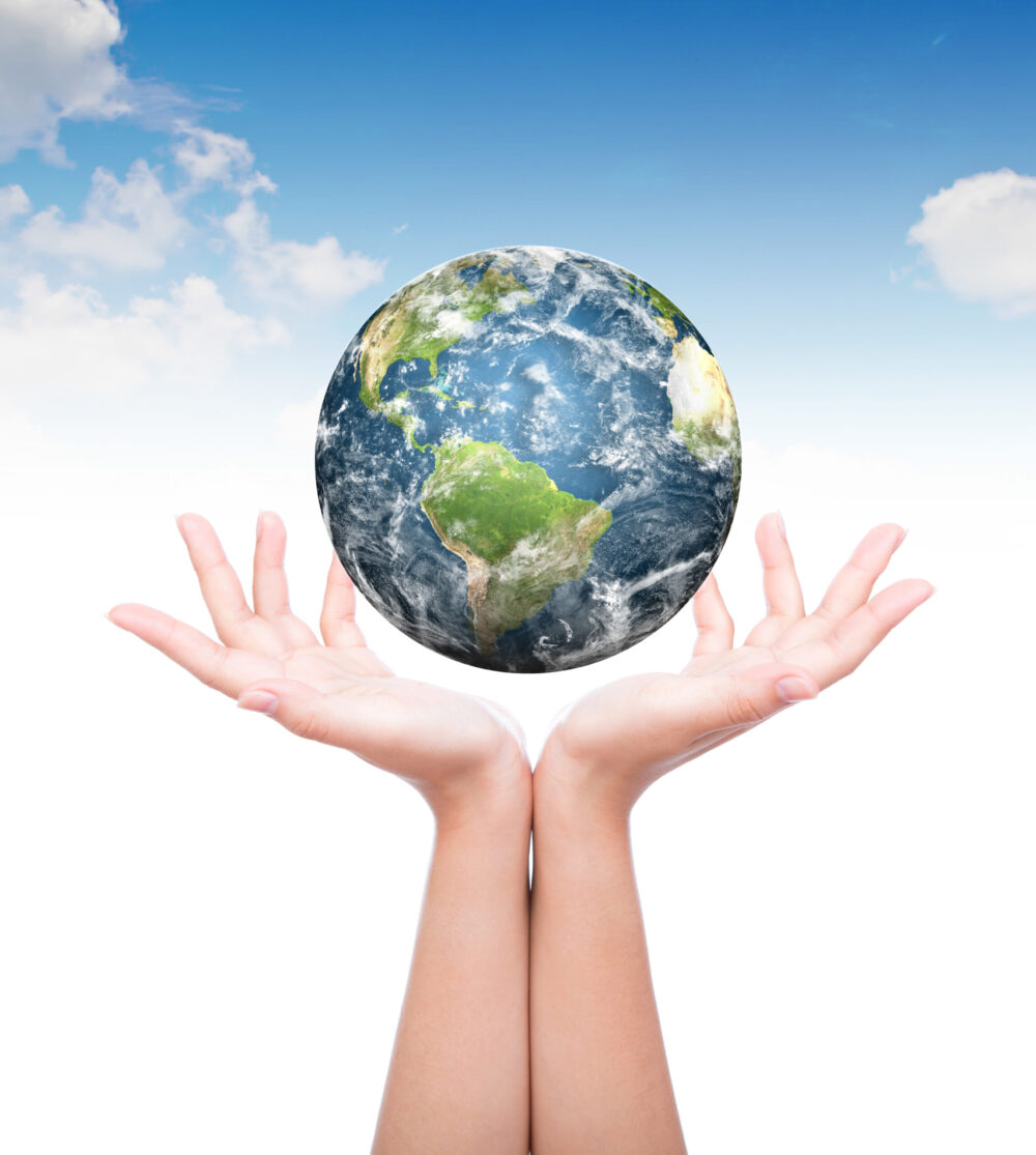 pair of hands holding up planet earth.